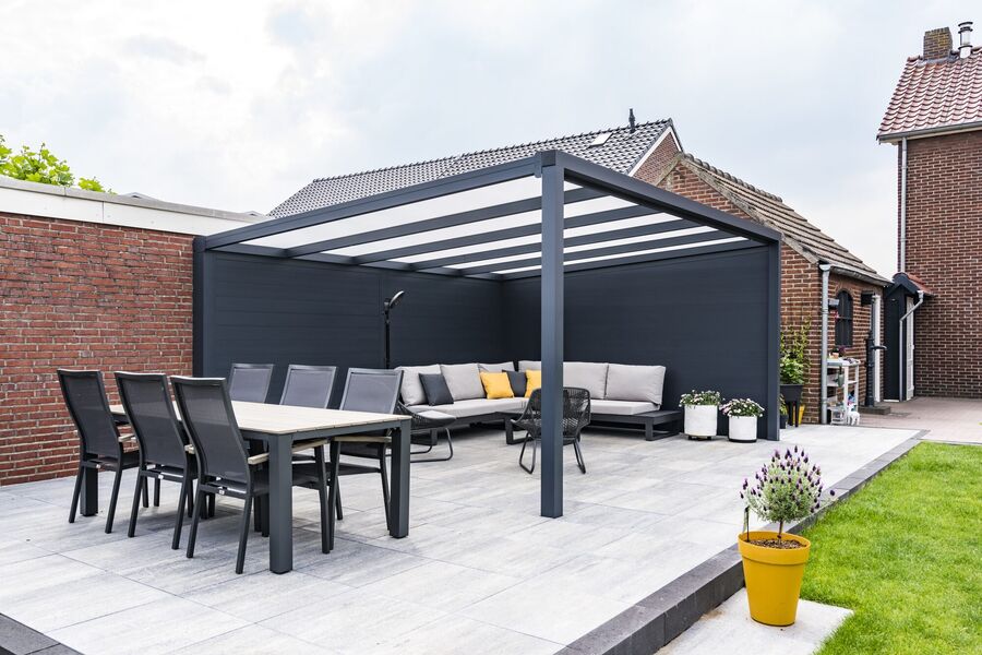 Anthrazitfarbene Terrassenüberdachung aus Aluminium mit Glasdach über Lounge- und Essbereich